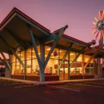 Googie space-age coffee shop at dusk with an upswept roof and neon sign